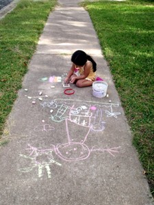 young girl drawing with chalk